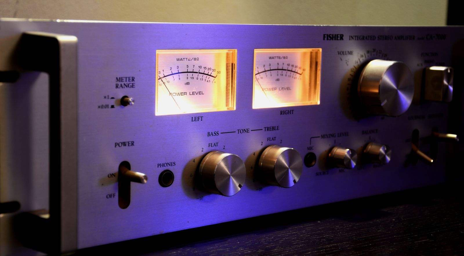 Vintage amplifier with glowing VU meters, dials and knobs