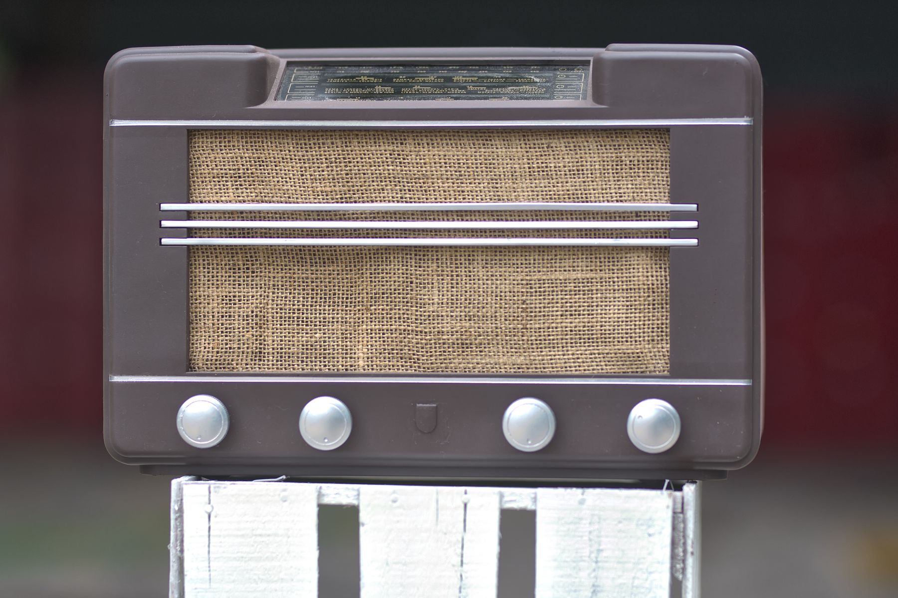 Vintage suitcase radio being repaired with hand tools on a workbench